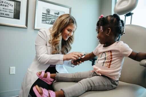 little girl with eczema skin treatment in dermatology office